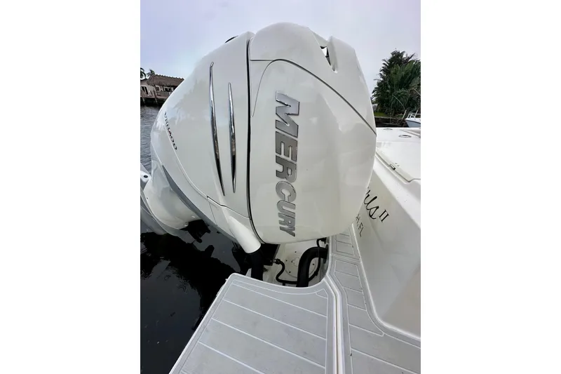 Slide: The Image of 2020 Boston Whaler 330 Outrage with Mercury outboard engine, docked by the water. - 23