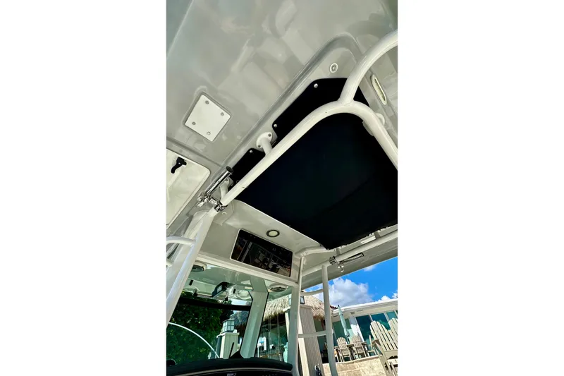 Slide: The Image of 2020 Boston Whaler 330 Outrage boat interior ceiling view with blue sky background. - 7