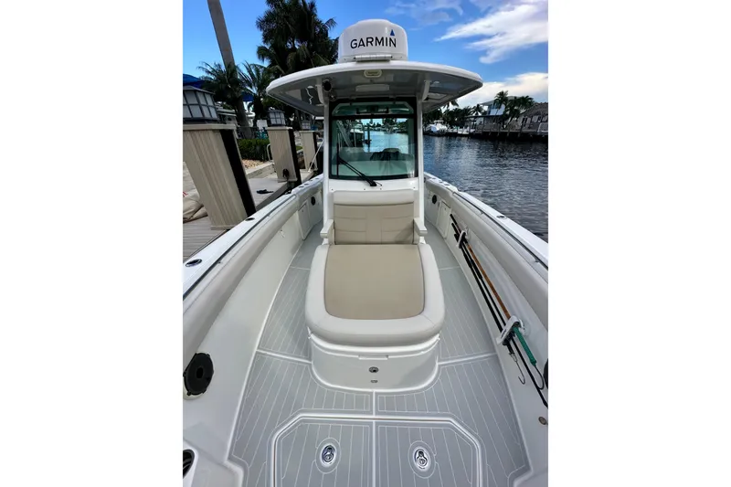 Slide: The Image of 2020 Boston Whaler 330 Outrage boat interior with Garmin equipment, docked by a waterfront. - 8