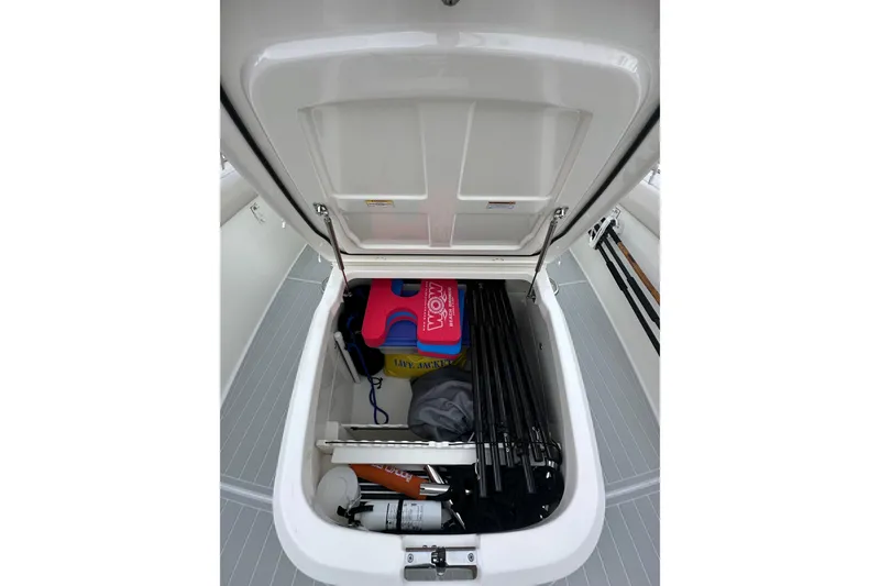 Slide: The Image of Open storage compartment on 2020 Boston Whaler 330 Outrage, containing life jackets and equipment. - 9