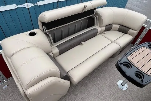 Slide: The Image of 2025 Sun Tracker Party Barge 24 DLX interior with beige seating and storage compartment. - 11
