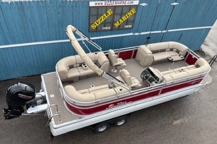 Slide: The Image of 2025 Sun Tracker Party Barge 24 DLX pontoon boat with beige seating and red accents. - 5