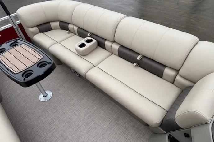 Slide: The Image of 2025 Sun Tracker Party Barge 24 DLX interior with beige seating and cup holders. - 7