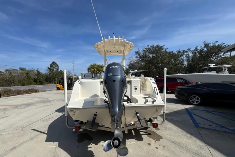 Slide: The Image of 2017 Cobia 220 Center Console boat with outboard motor in a parking lot. - 13