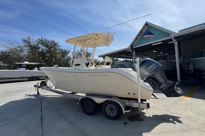 Slide: The Image of 2017 Cobia 220 Center Console boat on trailer, parked outdoors near a building. - 16