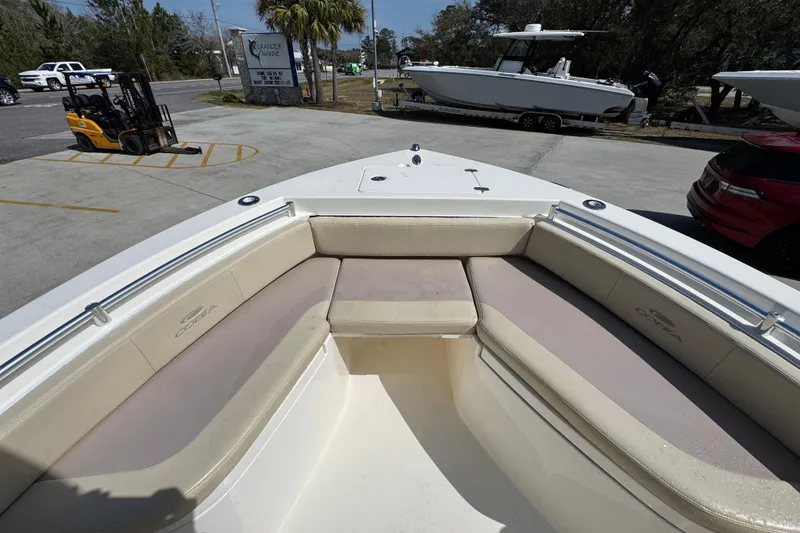 Slide: The Image of 2017 Cobia 220 Center Console boat with spacious seating at a marina. - 18