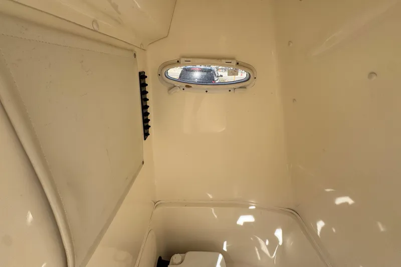 Slide: The Image of Interior cabin of 2017 Cobia 220 Center Console boat with small window. - 26