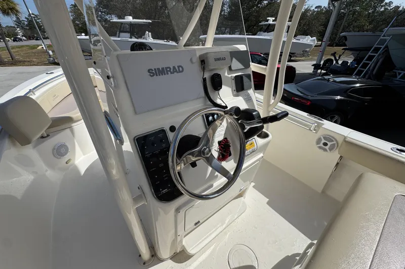 Slide: The Image of 2017 Cobia 220 Center Console boat with Simrad navigation system and steering wheel. - 30