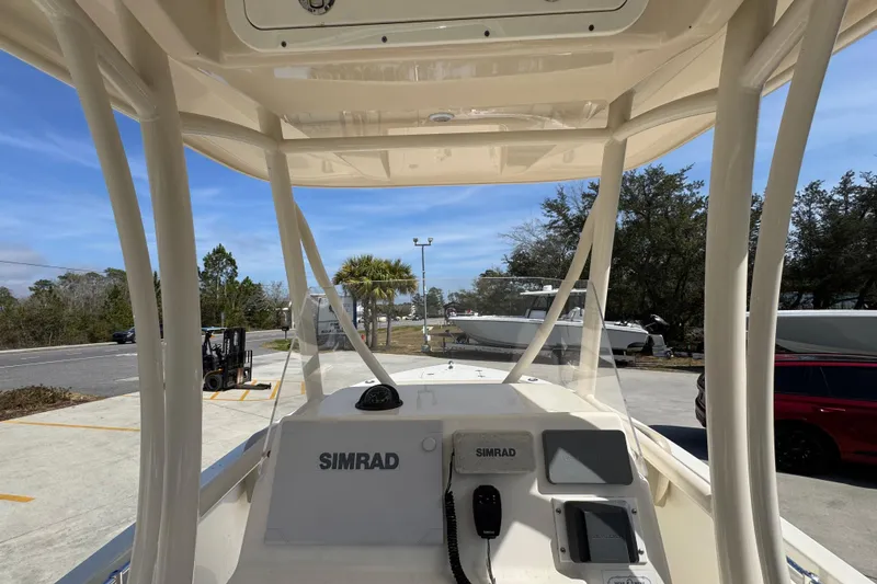Slide: The Image of 2017 Cobia 220 Center Console boat with Simrad navigation system, parked outdoors. - 32