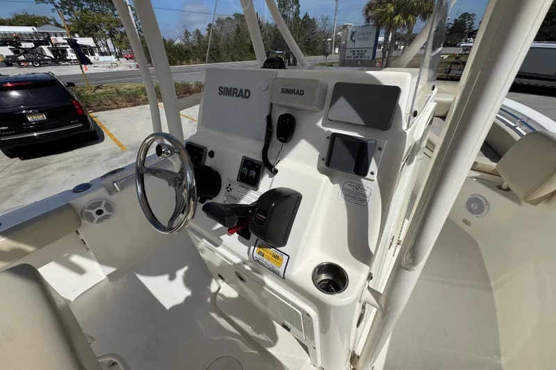 Slide: The Image of 2017 Cobia 220 Center Console boat dashboard with Simrad electronics and steering wheel. - 33