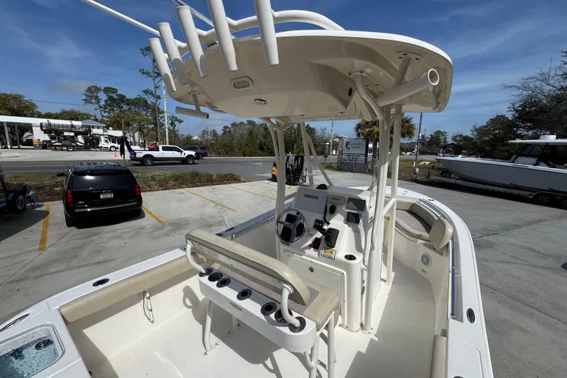 Slide: The Image of 2017 Cobia 220 Center Console boat with T-top and helm station in parking lot. - 36