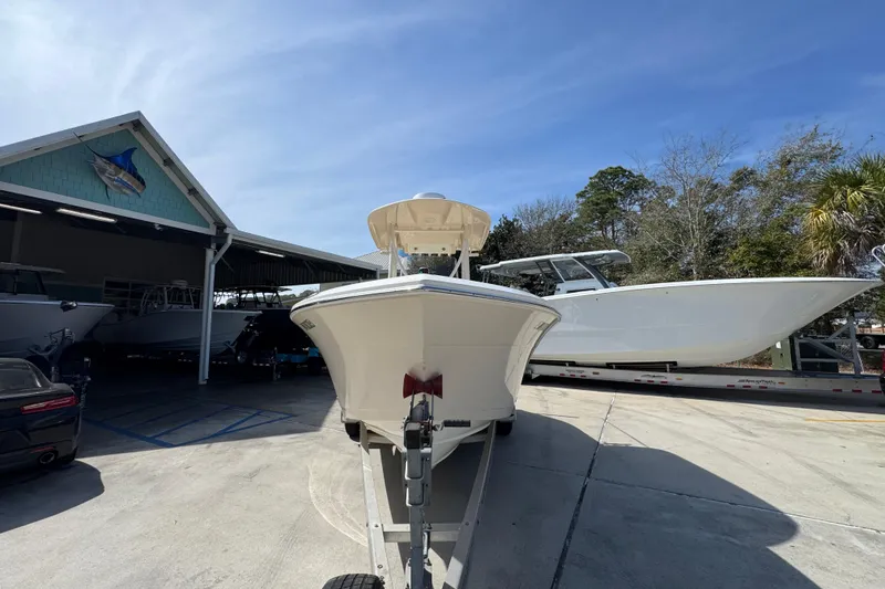 Slide: The Image of 2017 Cobia 220 Center Console boat on trailer at marina under clear sky. - 5