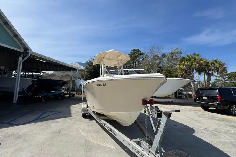 Slide: The Image of 2017 Cobia 220 Center Console boat on trailer in sunny outdoor setting. - 6