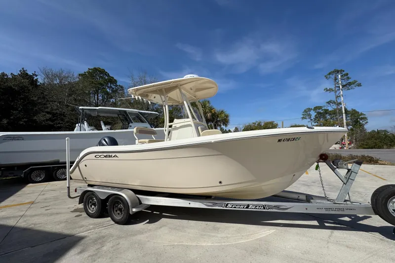 Slide: The Image of 2017 Cobia 220 Center Console boat on trailer, parked outdoors under clear sky. - 8