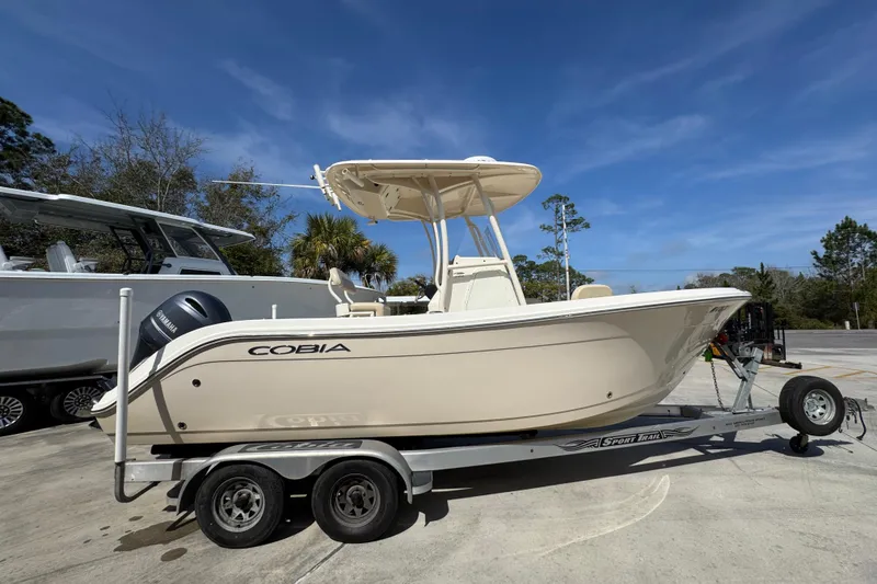 Slide: The Image of 2017 Cobia 220 Center Console boat on trailer, parked outdoors under clear sky. - 9