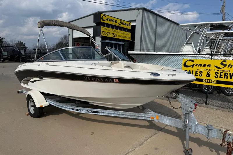 Slide: The Image of 2003 Sea Ray 185 Bow Rider boat on trailer at dealership, sunny day. - 0