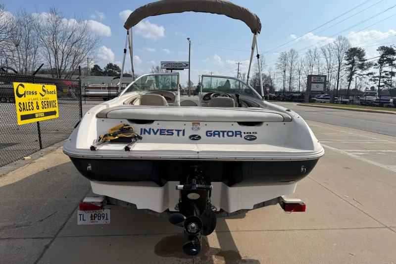 Slide: The Image of 2003 Sea Ray 185 Bow Rider boat at dealership, rear view with signage. - 4
