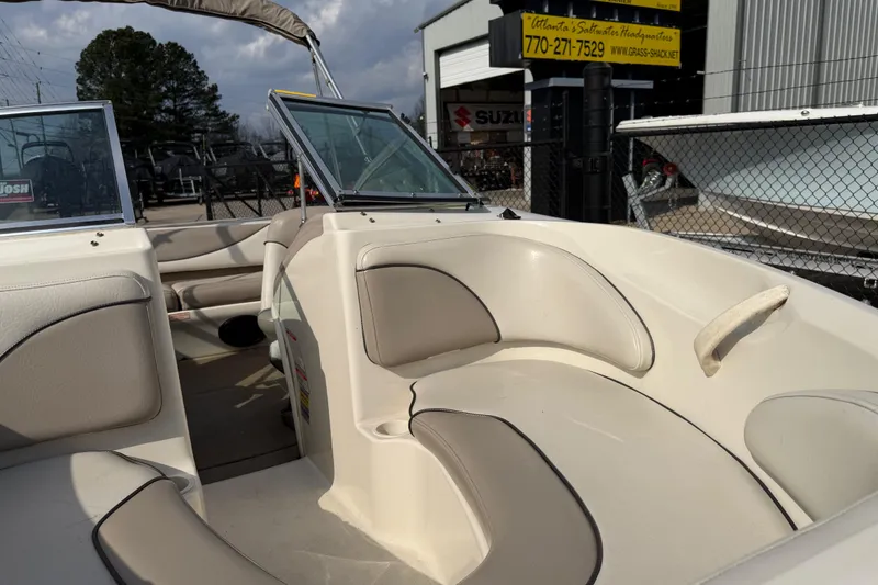 Slide: The Image of 2003 Sea Ray 185 Bow Rider interior with beige seating, parked at a dealership. - 8