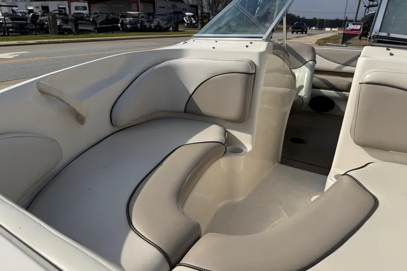 Slide: The Image of 2003 Sea Ray 185 Bow Rider interior with beige seating and cup holders. - 9