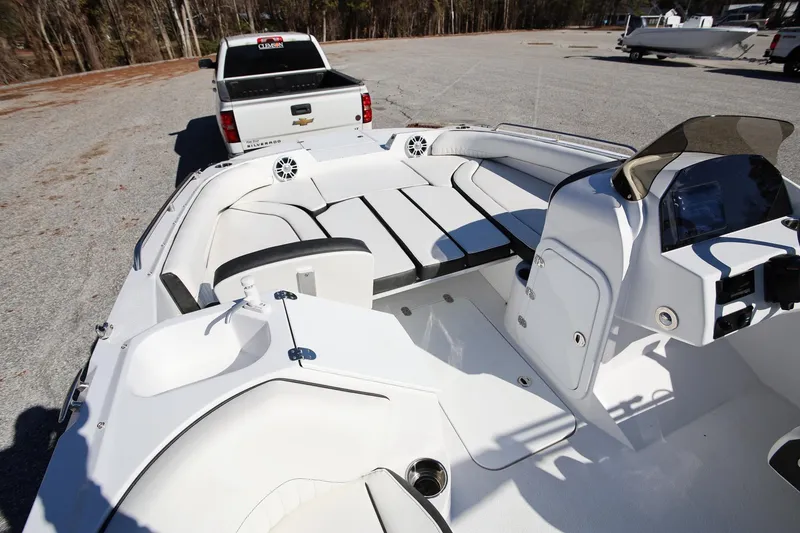Slide: The Image of 2025 Stingray 192 SC boat interior with seating and dashboard, parked near a Chevrolet Silverado. - 16