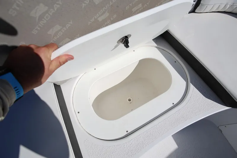 Slide: The Image of 2025 Stingray 192 SC boat storage compartment with open lid, showcasing interior space. - 26
