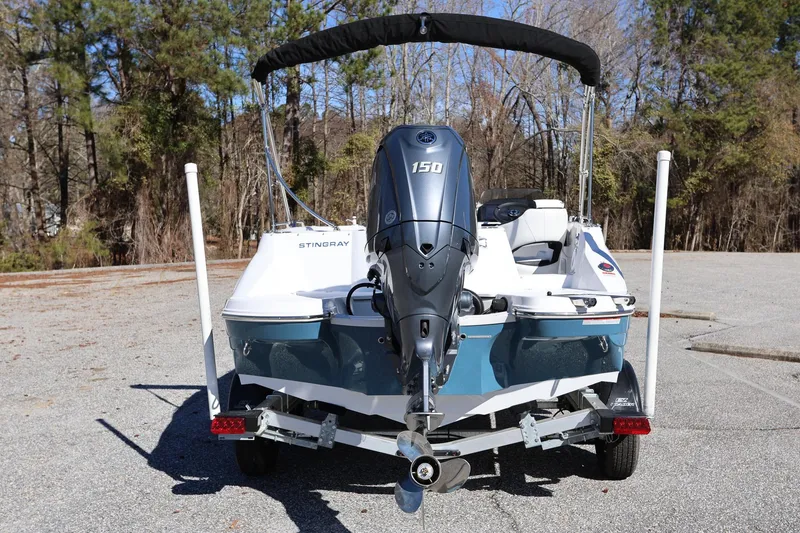 Slide: The Image of 2025 Stingray 192 SC boat with outboard motor on trailer, parked outdoors. - 3