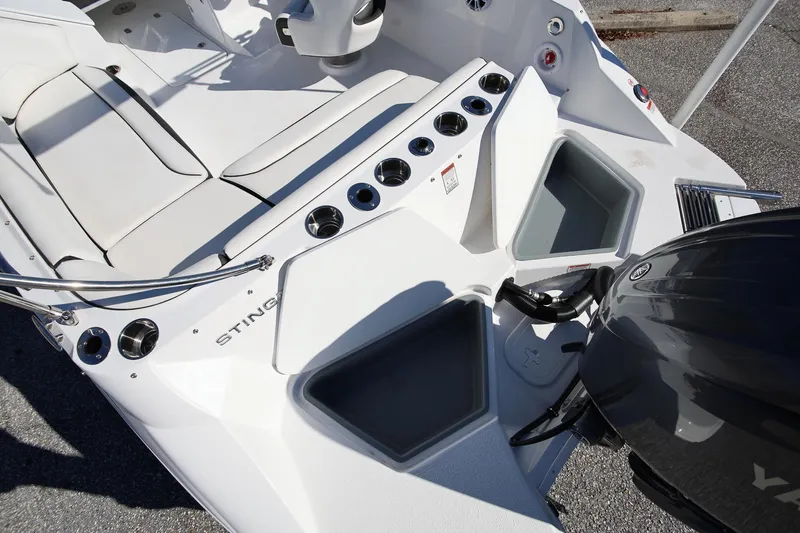 Slide: The Image of 2025 Stingray 192 SC boat interior with seating, storage compartments, and motor. - 7