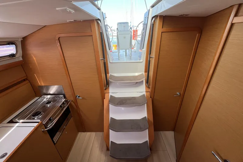Slide: The Image of Interior of 2017 Jeanneau Sun Odyssey 419 sailboat, featuring wooden cabinetry and compact kitchen. - 26