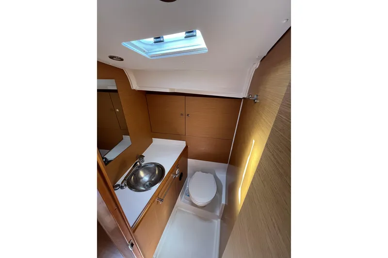 Slide: The Image of 2017 Jeanneau Sun Odyssey 419 bathroom with sink, toilet, and wooden cabinetry. - 31