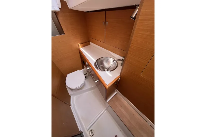 Slide: The Image of 2017 Jeanneau Sun Odyssey 419 bathroom with wooden cabinetry, sink, and toilet. - 33
