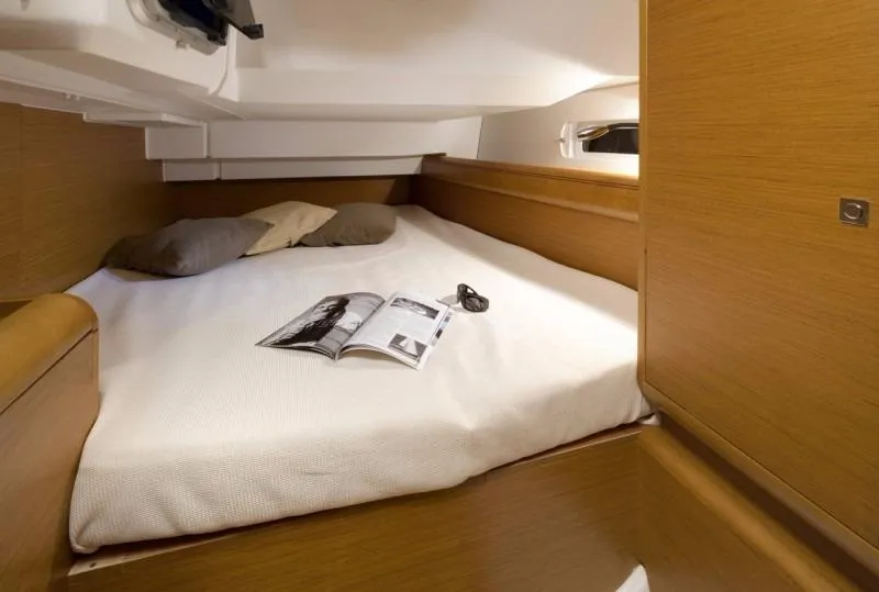 Slide: The Image of Manufacturer Provided Image: Cozy cabin interior of 2017 Jeanneau Sun Odyssey 419 with bed and reading material. - 6