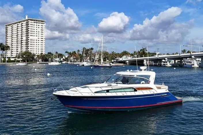 Slide: The Image of 2007 Chris-Craft Roamer 40 yacht cruising on blue water near a bridge. - 2