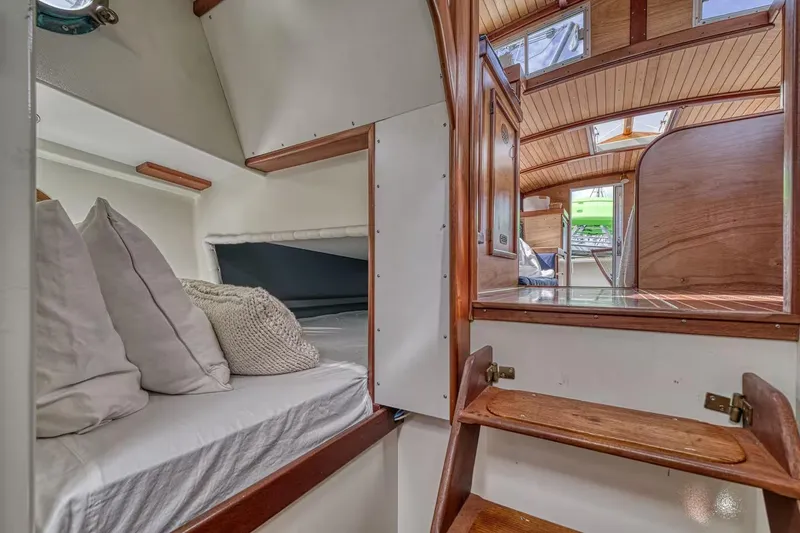 Slide: The Image of Cozy cabin interior of 1996 Devlin 38 boat with wooden accents and bedding. - 11
