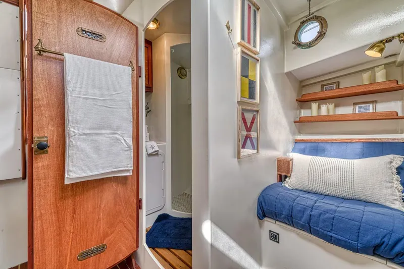 Slide: The Image of Cozy interior of 1996 Devlin 38 boat with wooden door, blue seating, and nautical decor. - 12