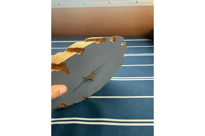 Slide: The Image of Damaged wooden piece from a 1996 Devlin 38 boat, showing cracks and splinters. - 21