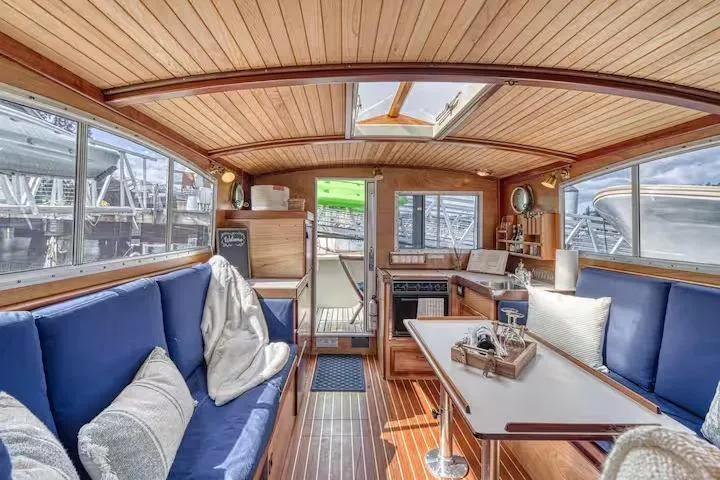 Slide: The Image of Interior of 1996 Devlin 38 boat with wooden finish and blue seating. - 4