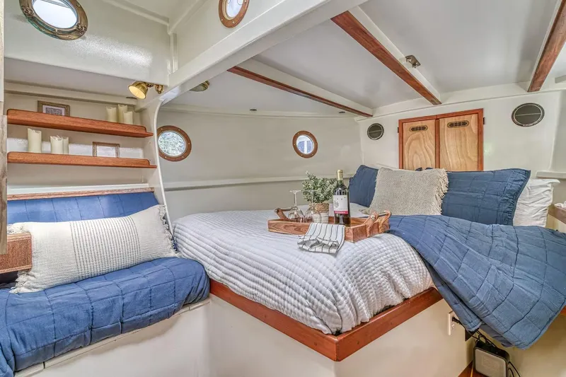 Slide: The Image of Cozy 1996 Devlin 38 boat cabin with elegant bedding and wooden accents. - 9