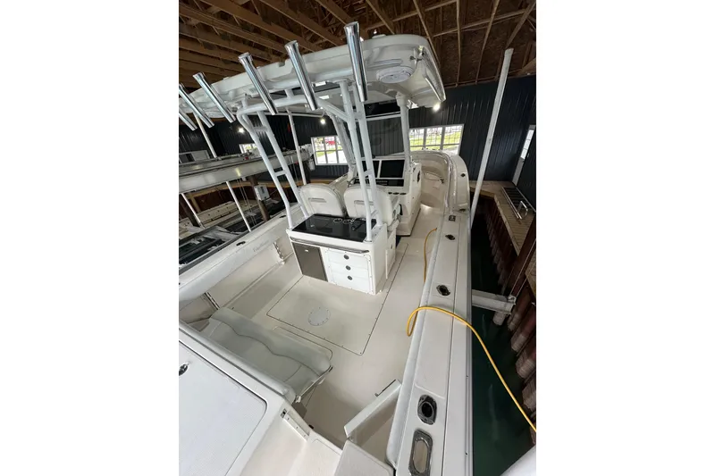 Slide: The Image of 2015 Edgewater 320CC boat interior with seating and control panel in a docked setting. - 10