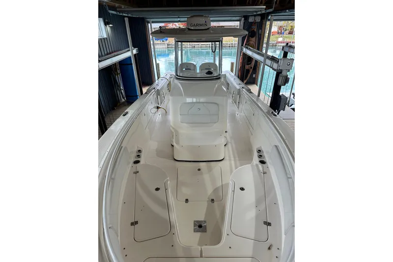 Slide: The Image of 2015 Edgewater 320CC boat in dock, featuring spacious deck and modern design. - 6