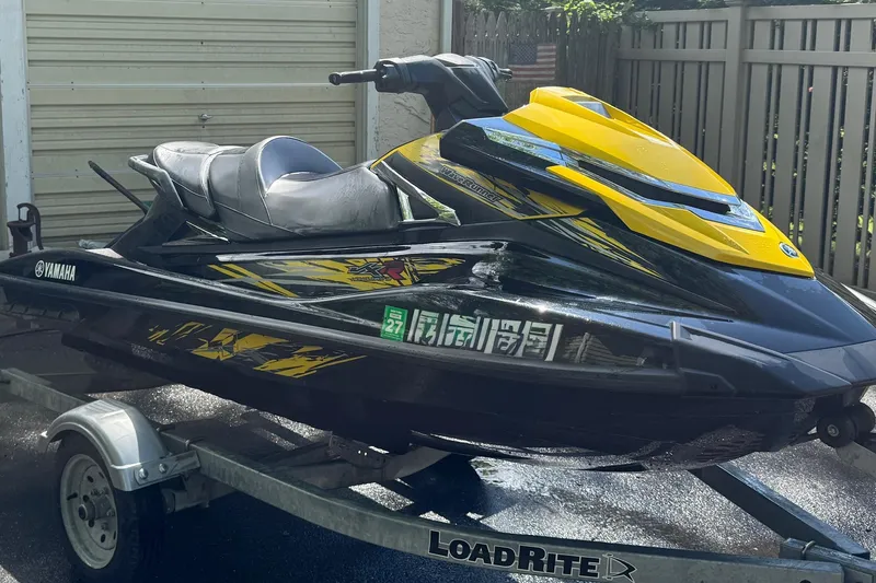 The Image of 2015 Yamaha WaveRunner VXR jet ski on trailer, black and yellow design. - 0
