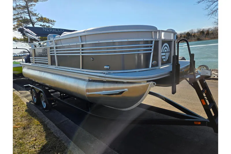Slide: The Image of 2024 Nepallo 18TL pontoon boat on trailer by a lake. - 8