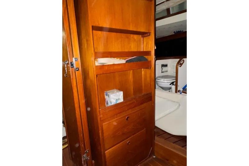 Slide: The Image of Interior of 1988 Sabre 42 yacht showing wooden cabinetry and a compact bathroom. - 11