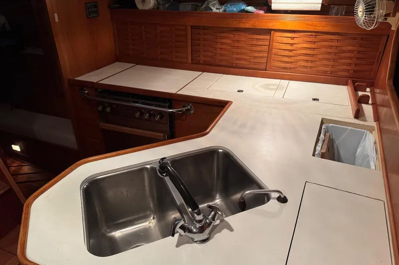 Slide: The Image of 1988 Sabre 42 yacht kitchen with stainless steel sink and wooden cabinetry. - 16