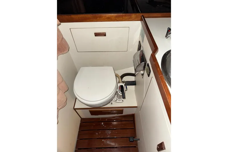Slide: The Image of 1988 Sabre 42 yacht bathroom with wooden accents and compact toilet. - 19
