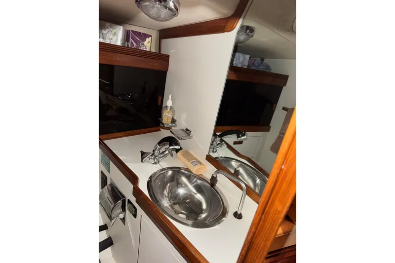 Slide: The Image of 1988 Sabre 42 yacht bathroom with sink, mirror, and wooden accents. - 20
