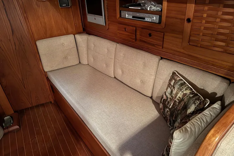 Slide: The Image of Interior of 1988 Sabre 42 yacht with beige cushioned seating and wooden cabinetry. - 7