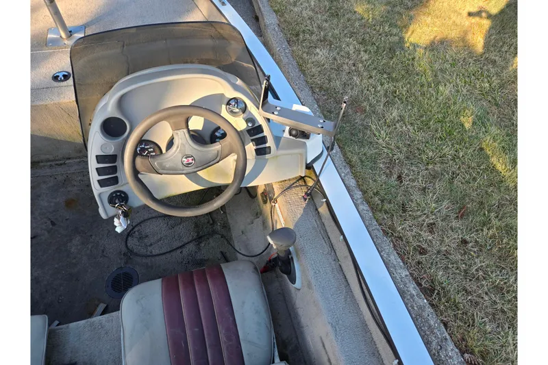 Slide: The Image of Steering console of a 2002 Ranger 116 Cherokee boat, featuring a beige dashboard and controls. - 11