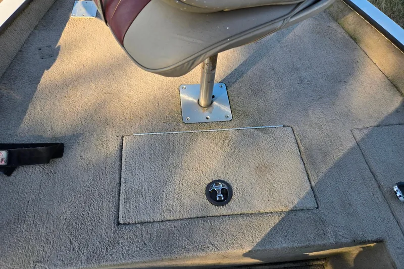 Slide: The Image of 2002 Ranger 116 Cherokee boat interior with seat and storage compartment. - 15