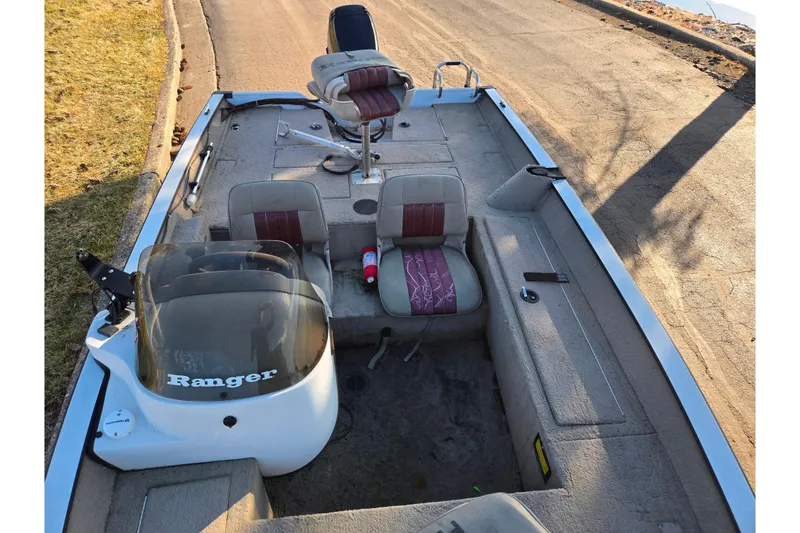 Slide: The Image of 2002 Ranger 116 Cherokee boat interior with seats and steering console. - 17