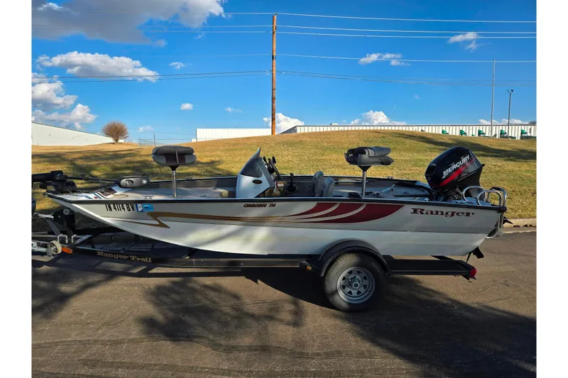Slide: The Image of 2002 Ranger 116 Cherokee boat on trailer, parked outdoors under blue sky. - 4